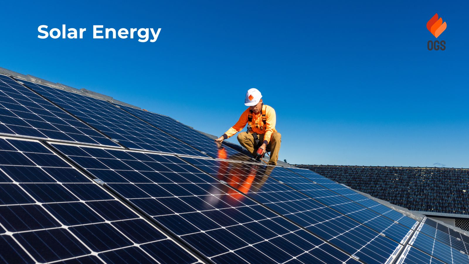 Technician in safety gear working on a rooftop solar array